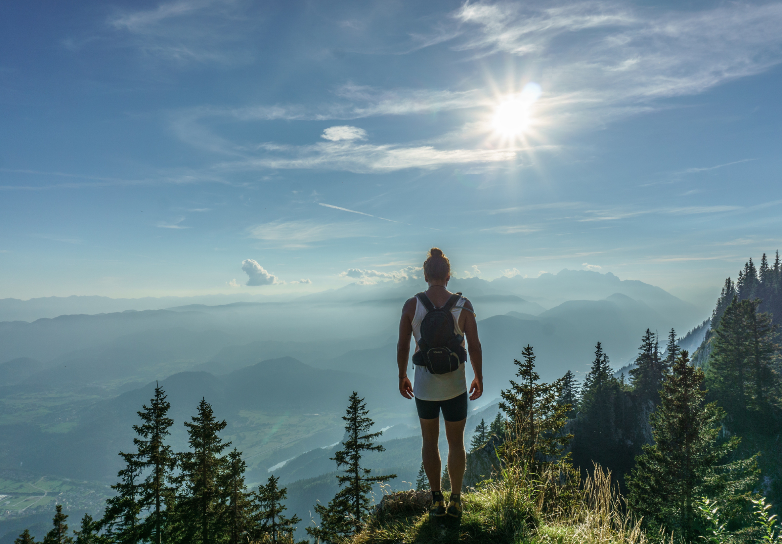 Wanderer überblickt von einem Gipfel ein weites Bergpanorama